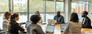 Group of professionals in a modern conference room discussing real estate strategies, with laptops open, highlighting collaboration and business insights in Winston Salem.